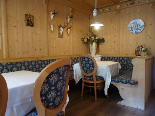 a dining room with a table and two chairs at Garni Pineta in San Martino in Badia