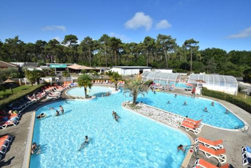 un groupe de personnes dans une piscine d'un complexe hôtelier dans l'établissement Camping Officiel Siblu Les Viviers, à Lège-Cap-Ferret