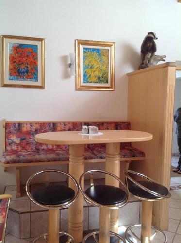 a table and stools in a waiting room with a bench at Garni Pineta in San Martino in Badia