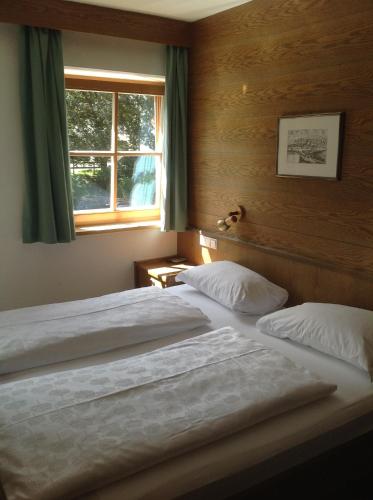 a bedroom with two beds and a window at Garni Pineta in San Martino in Badia