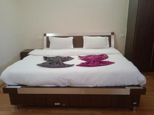 un letto con due cappelli e asciugamani sopra di Orion Home a Leh