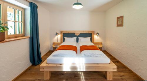 a bedroom with a bed with two orange sheets at Ecologie Grundlsee in Grundlsee