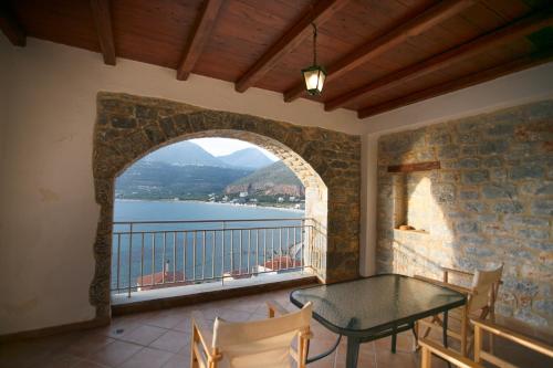 a balcony with a table and a view of the water at Traditional Apartments Plagiaki in Neon Oitilon