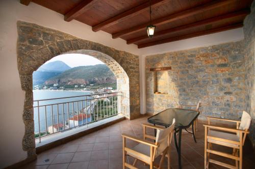 a balcony with a table and chairs and a window at Traditional Apartments Plagiaki in Neon Oitilon