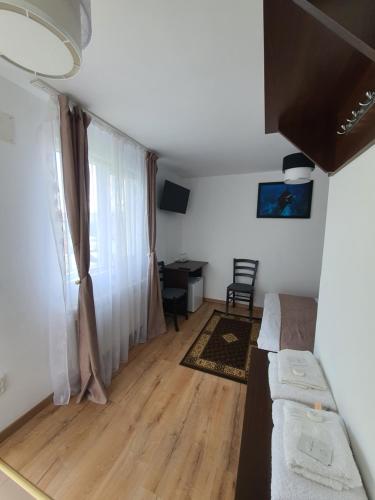 a living room with a couch and a desk at Pensiunea Stan in Cisnădie