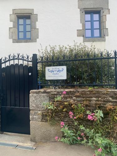 une porte menant à une maison avec un panneau sur celle-ci dans l'établissement La cour des Ursulines, à Josselin