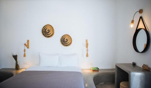 a bedroom with a bed and a mirror on the wall at Aetheria Villas in Oia