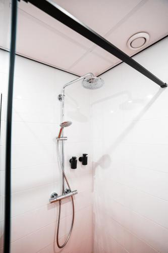 a shower in a bathroom with white walls at Neon Nights Studio in Groningen