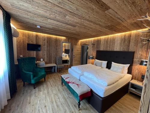 1 dormitorio con 1 cama grande y 1 silla verde en Das kleine Landhotel, en Dorsten