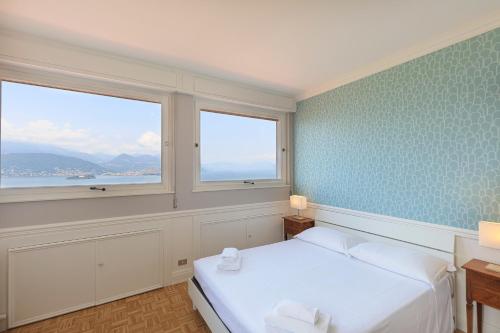 una camera con due letti e due finestre di Miralago Stresa a Stresa