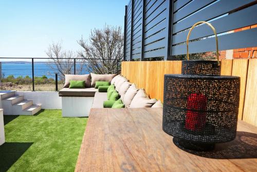d'une terrasse avec un canapé, une table et de la pelouse. dans l'établissement Villa Seabatical, à Ražanac