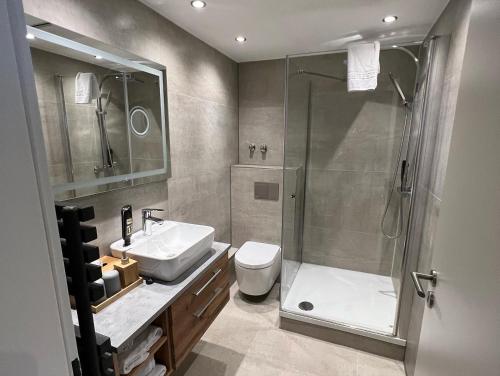 a bathroom with a shower and a toilet and a sink at Das kleine Landhotel in Dorsten