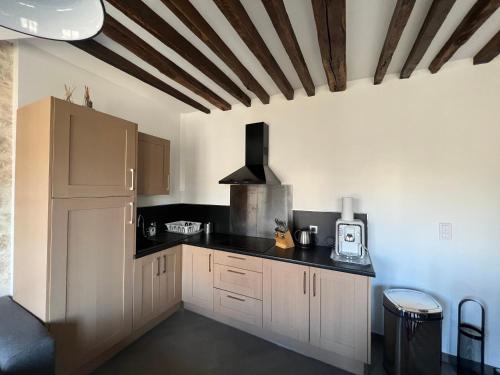 une cuisine avec des armoires blanches et des comptoirs noirs dans l'établissement duplexparisrepublique, à Paris