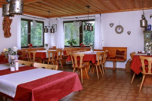 - une salle à manger avec des tables, des chaises et des fenêtres dans l'établissement Landhaus am Forst - Apartments, à Bad Alexandersbad