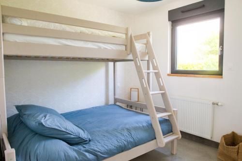 łóżko piętrowe z drabiną i niebieską poduszką w obiekcie Charmante maison pour 5 au coeur de Penmarch w mieście Penmarch