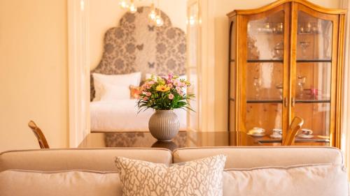 uma sala de estar com um vaso de flores sobre uma mesa em Residence Dvorak em Praga