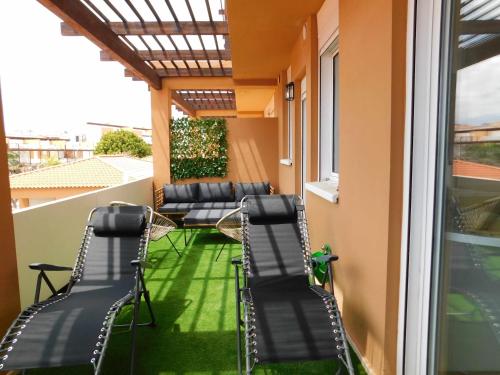 a patio with chairs and a window on a balcony at Ocean Sun & Golf II in San Miguel de Abona