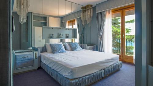 a bedroom with a large bed with blue walls at CALA 51 - Villa with sea view in Blanes