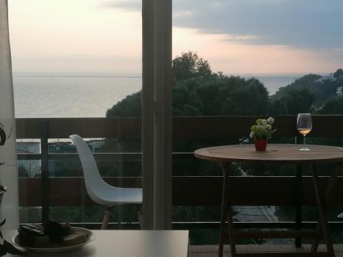 a table and a glass of wine on a balcony at Canyelles Apartament in Roses