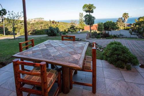 a wooden table and chairs on a patio at 2 Bedroom Holiday Flat in Dana Bay in Mossel Bay