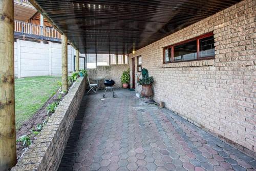 an outdoor patio with a brick wall and a grill at 2 Bedroom Holiday Flat in Dana Bay in Mossel Bay