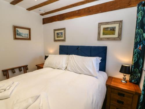 a bedroom with a large bed with a blue headboard at Ty Gwennol in Beaumaris