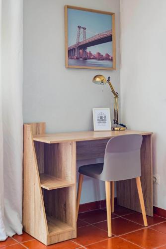 a wooden desk with a chair and a lamp at La Maison in Anobra