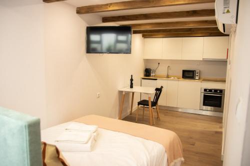 ein kleines Zimmer mit einem Bett und einer kleinen Küche in der Unterkunft Apartamentos do Corgo in Vila Real