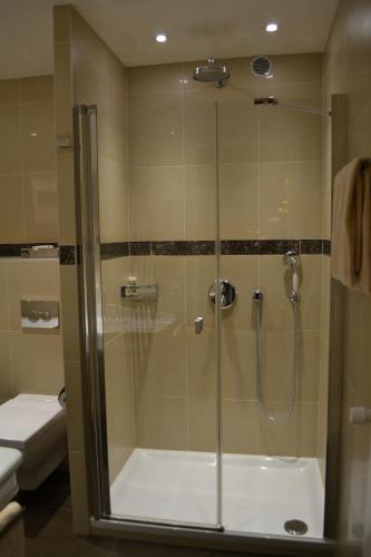 a shower with a glass door in a bathroom at Hotel Adriatica in Geneva