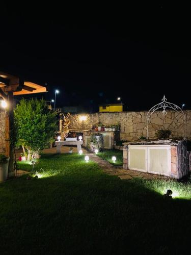 a garden at night with a bench in the grass at B&B Il Sentiero in San Sperate