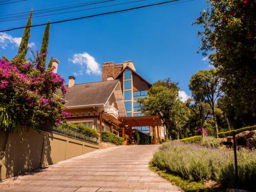 une maison avec des fleurs sur le côté d'une allée dans l'établissement Hotel Monte Felice Bosque, à Gramado