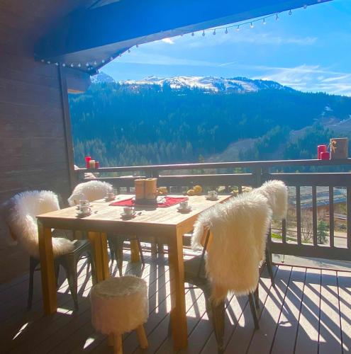 une table et des chaises sur un balcon avec vue dans l'établissement Penthouse l'Ourse Bleue - Sauna privatif - accès direct aux pistes, à Courchevel