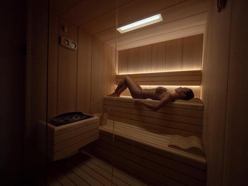 a woman is laying in a sauna at Vivid Blue Serenity Resort in Sveti Stefan