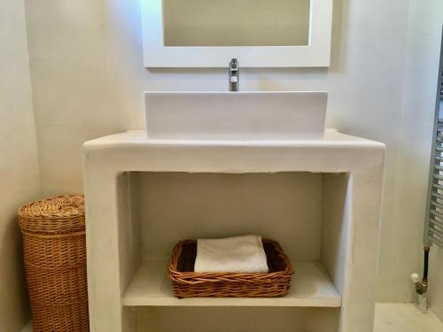 a bathroom with a white sink and a basket at Villa Magdalena in Epáno Kefalás