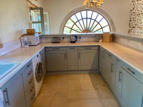 a large kitchen with blue cabinets and a sink at Villa Magdalena in Epáno Kefalás