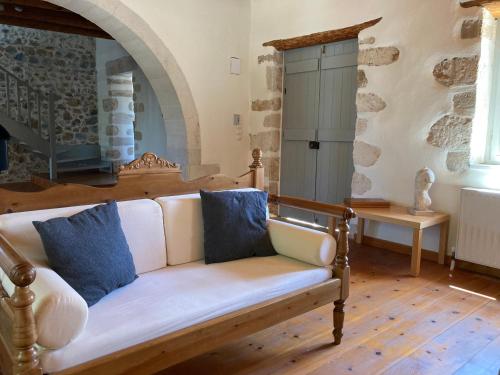 a living room with a white couch with blue pillows at Villa Magdalena in Epáno Kefalás