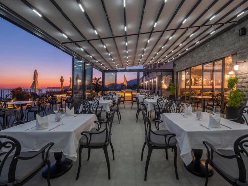 a restaurant with tables and chairs with a view at Vivid Blue Serenity Resort in Sveti Stefan