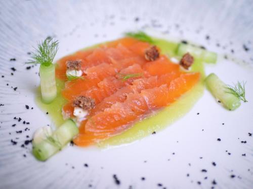 a plate of food with salmon and other vegetables at Vivid Blue Serenity Resort in Sveti Stefan