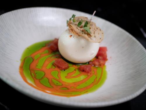 a white plate of food with an egg on top at Vivid Blue Serenity Resort in Sveti Stefan
