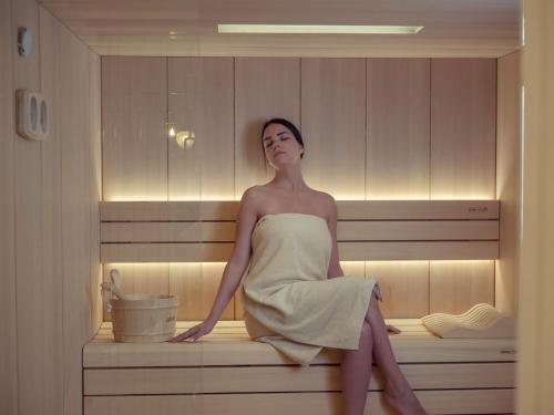 a woman is sitting in a bath tub at Vivid Blue Serenity Resort in Sveti Stefan
