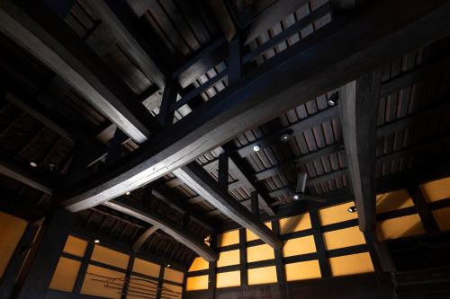an empty room with wooden ceilings and windows at TOKI NO YADO in Nakanogō