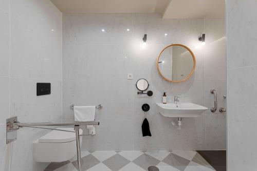 Baño blanco con lavabo y espejo en Gran Alameda by Caleta Homes, en Málaga