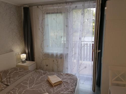 a bedroom with a bed next to a window at Penzion V Roklich & Apartmens V Roklich in Ricany
