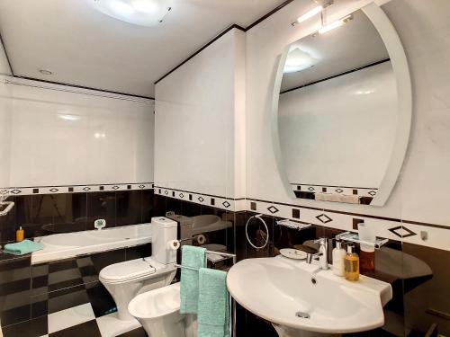 a bathroom with a sink and a toilet and a mirror at Vila Formosa Top View by LovelyStay in Funchal