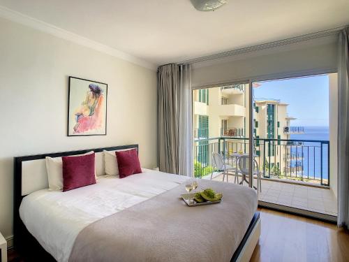a bedroom with a large bed and a balcony at Vila Formosa Top View by LovelyStay in Funchal