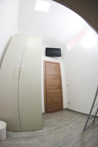a room with a door and a television on a wall at That's AMORO house in Pozzallo