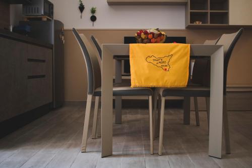a dining room table with a yellow napkin on it at That's AMORO house in Pozzallo