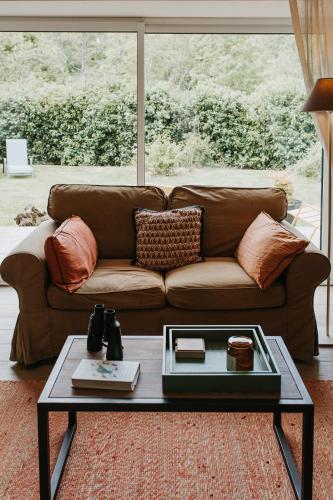 a brown couch in a living room with a coffee table at Gîtes du Bulz, en pleine forêt proche de la mer in Pleyber-Christ