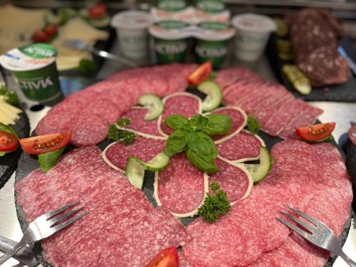 a bunch of meat on a table with forks at Landhotel Der Distelhof mit Scheunencafé in Dillstädt