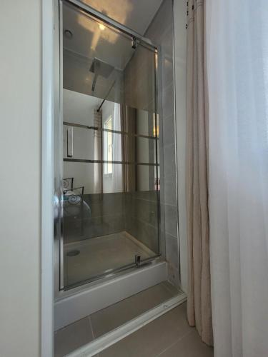 y baño con ducha y puerta de cristal. en Coup de Soleil, en Juvignac